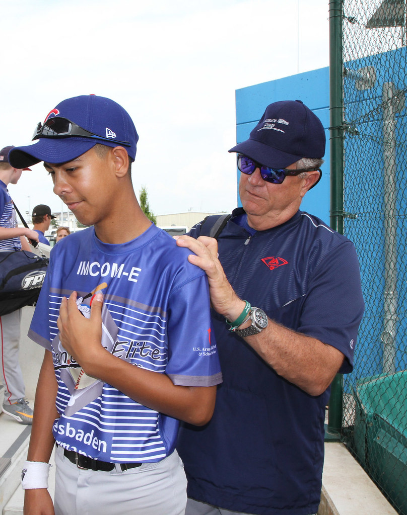 Academy coach with his arm around a young player on the field